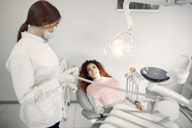 Hermosa niña sentada en el consultorio del dentista