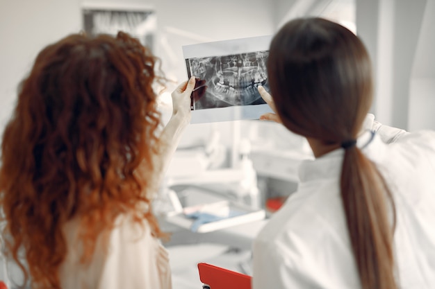 Foto gratuita hermosa niña sentada en el consultorio del dentista