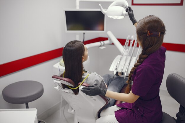 Hermosa niña sentada en el consultorio del dentista