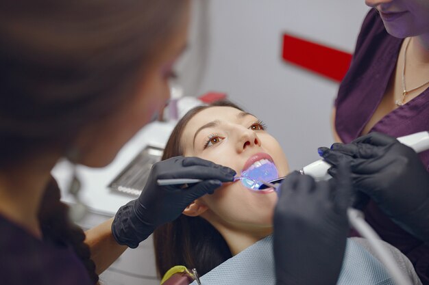 Hermosa niña sentada en el consultorio del dentista