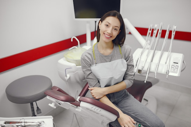 Foto gratuita hermosa niña sentada en el consultorio del dentista
