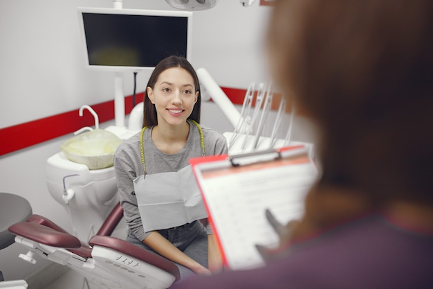 Foto gratuita hermosa niña sentada en el consultorio del dentista