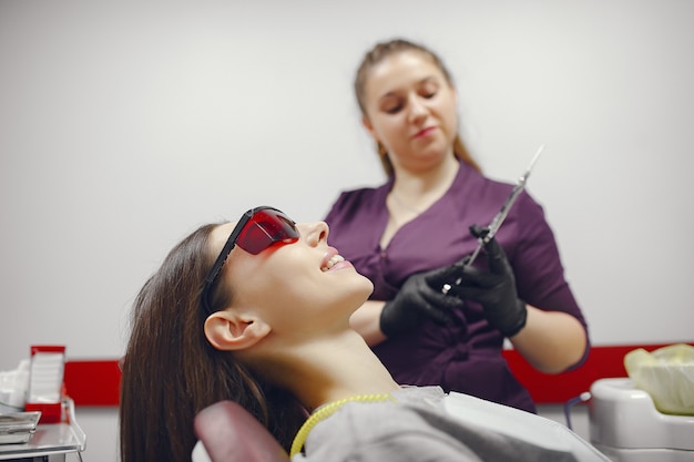 Hermosa niña sentada en el consultorio del dentista