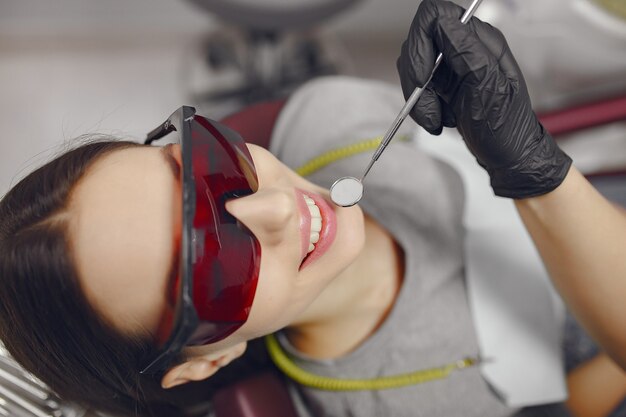 Hermosa niña sentada en el consultorio del dentista