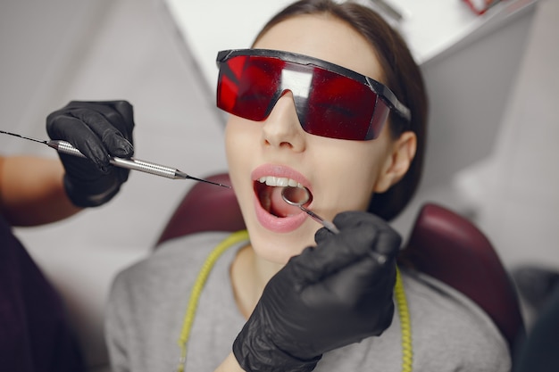 Hermosa niña sentada en el consultorio del dentista