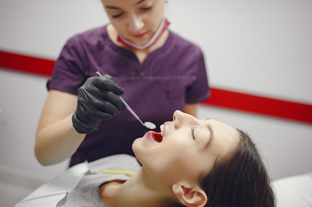 Hermosa niña sentada en el consultorio del dentista