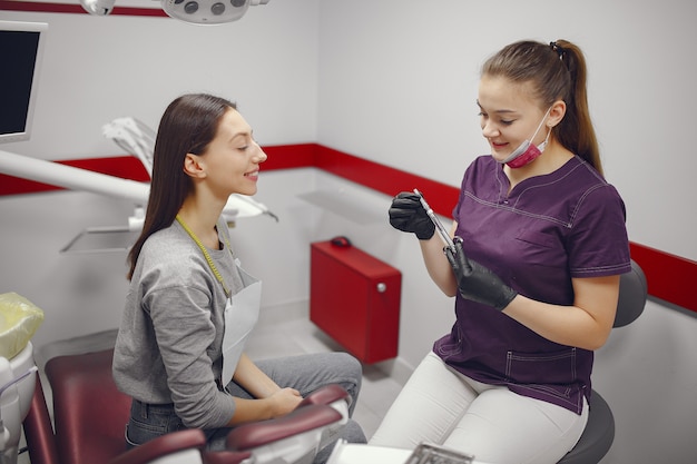 Hermosa niña sentada en el consultorio del dentista