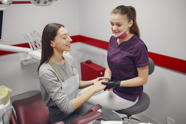 Hermosa niña sentada en el consultorio del dentista