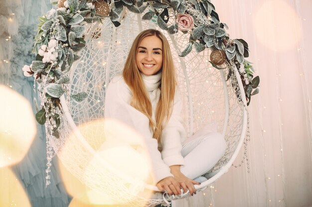 Hermosa niña sentada en un estudio con regalos