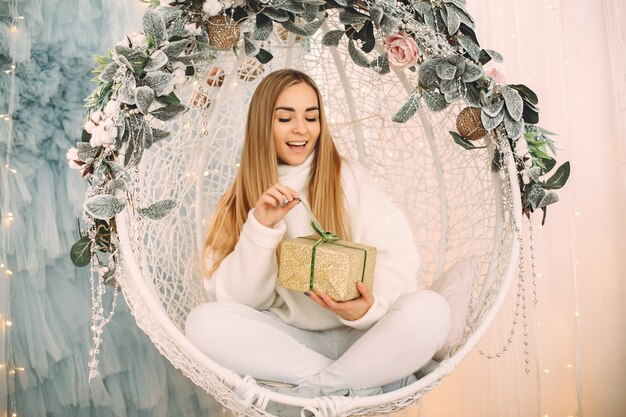 Hermosa niña sentada en un estudio con regalos