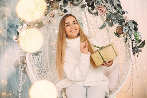 Hermosa niña sentada en un estudio con regalos