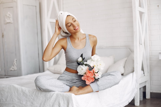 Hermosa niña sentada en su casa en una cama