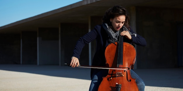 hermosa niña toca el cello con pasión en un ambiente concreto