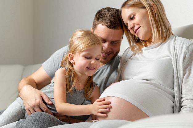 Hermosa niña tocando el vientre de la madre