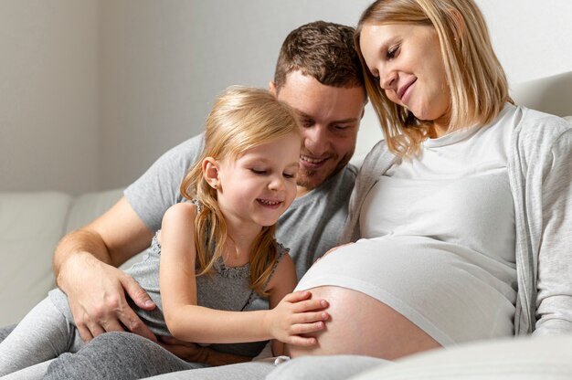 Hermosa niña tocando el vientre de la madre