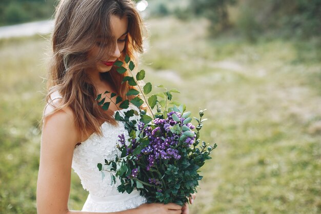 Hermosa novia caminando en un campo de verano