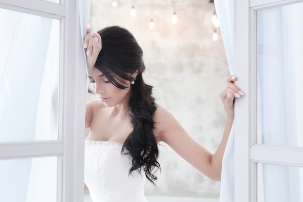 Hermosa novia mujer en vestido de novia con un ramo de flores