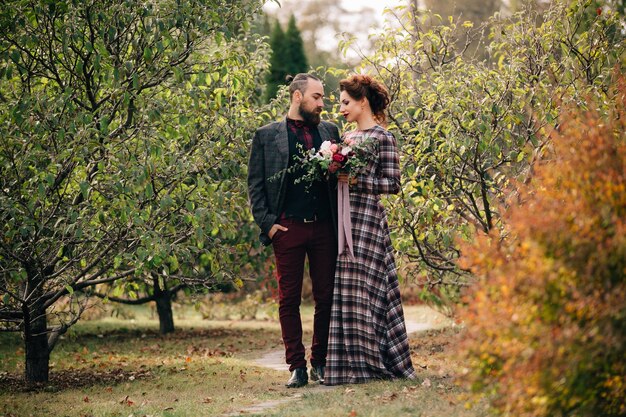 Hermosa novia y el novio caminar en el jardín después de la ceremonia de la boda