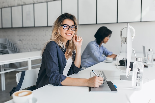 Hermosa oficinista realizando trabajos administrativos para empresa