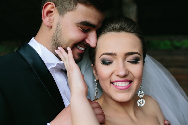 Hermosa pareja abrazándose al aire libre en la cabaña de madera, un ángulo cercano