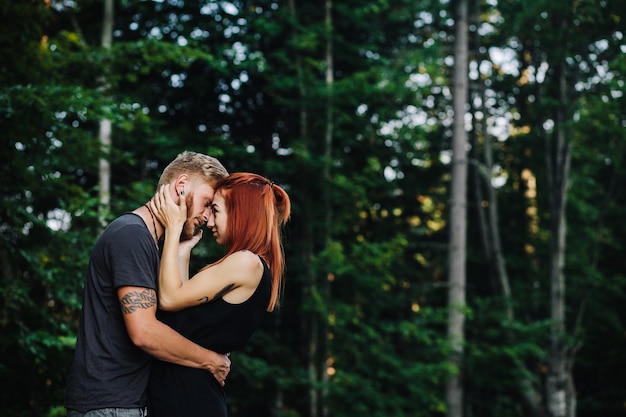 Hermosa pareja abrazándose en el fondo del bosque