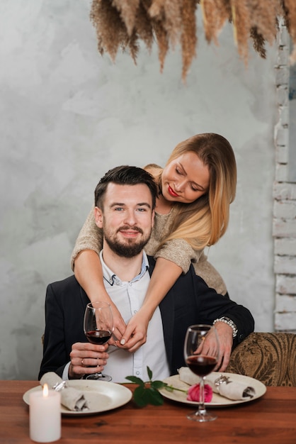 Foto gratuita hermosa pareja abrazándose en la mesa