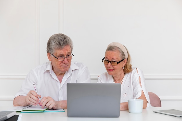 Hermosa pareja de abuelos aprendiendo a usar la computadora portátil