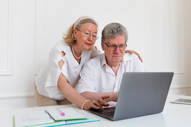 Hermosa pareja de abuelos aprendiendo a usar dispositivos digitales