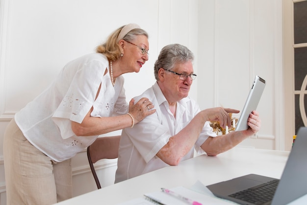 Hermosa pareja de abuelos aprendiendo a usar dispositivos digitales