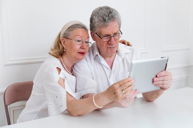 Hermosa pareja de abuelos aprendiendo a usar dispositivos digitales