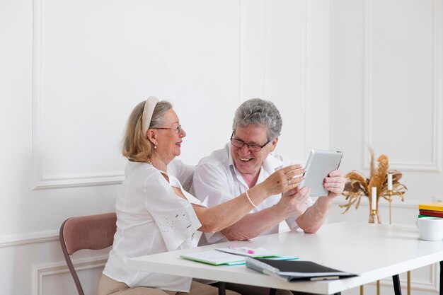 Hermosa pareja de abuelos aprendiendo a usar dispositivos digitales