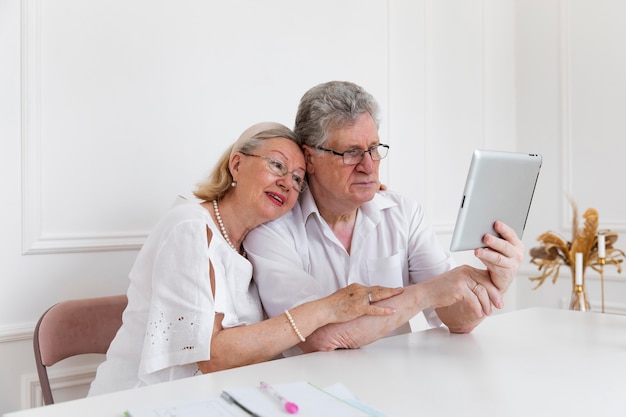 Hermosa pareja de abuelos aprendiendo a usar dispositivos digitales