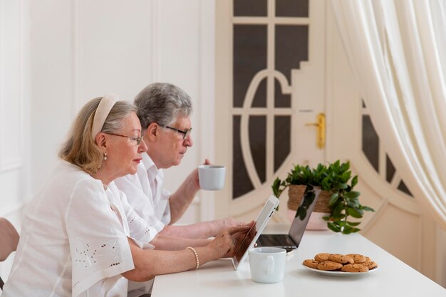Hermosa pareja de abuelos aprendiendo a usar dispositivos digitales
