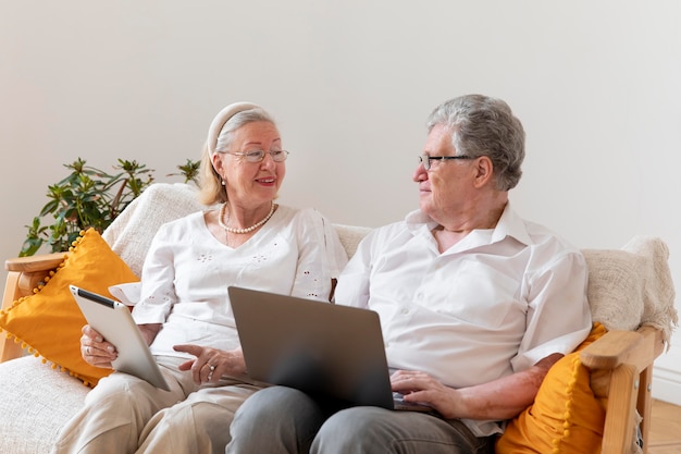 Hermosa pareja de abuelos aprendiendo a usar dispositivos digitales