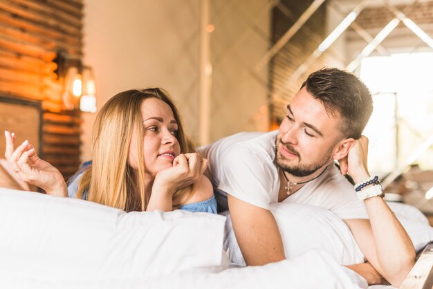 Hermosa pareja acostada en la cama mirando el uno al otro