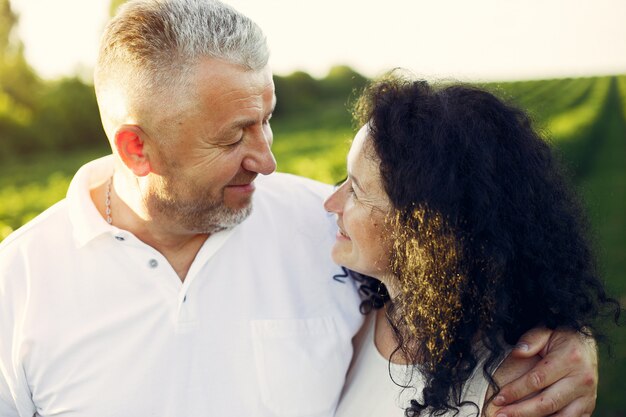 Hermosa pareja adulta pasa tiempo en un campo de verano