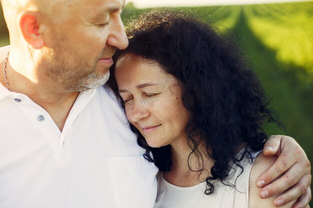 Hermosa pareja adulta pasa tiempo en un campo de verano