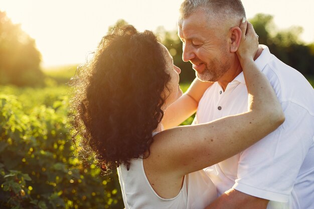 Hermosa pareja adulta pasa tiempo en un campo de verano