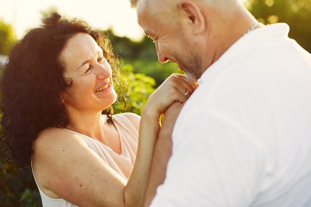 Hermosa pareja adulta pasa tiempo en un campo de verano