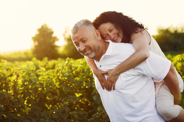 Hermosa pareja adulta pasa tiempo en un campo de verano