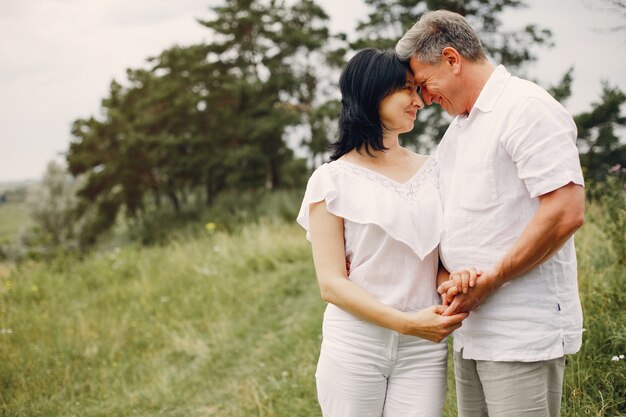 Hermosa pareja adulta pasa tiempo en un campo de verano