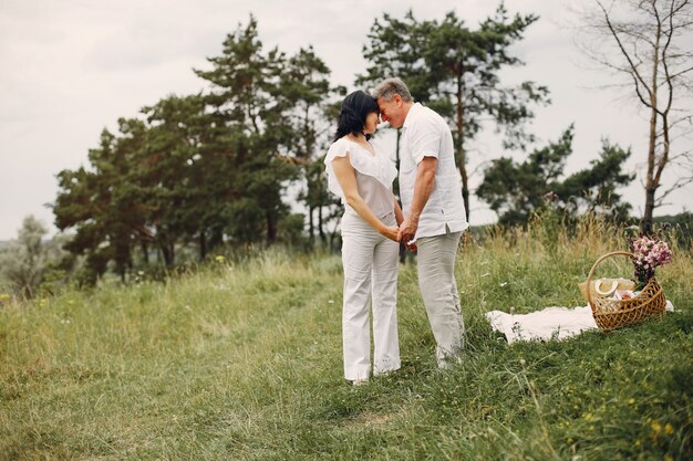 Hermosa pareja adulta pasa tiempo en un campo de verano