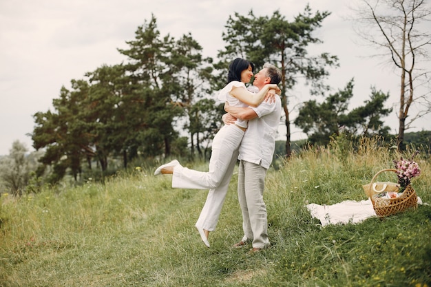 Hermosa pareja adulta pasa tiempo en un campo de verano