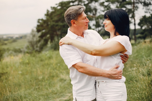 Hermosa pareja adulta pasa tiempo en un campo de verano