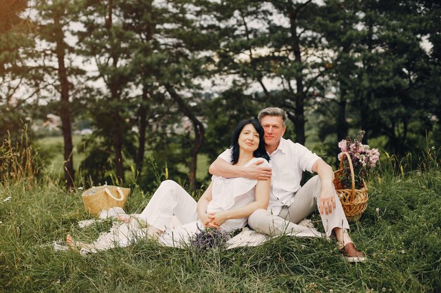 Hermosa pareja adulta pasa tiempo en un campo de verano