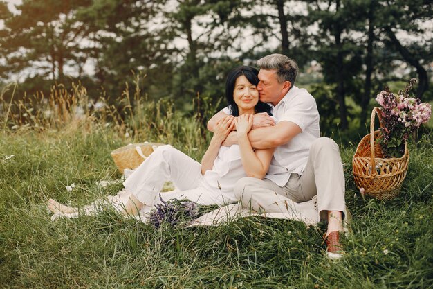 Hermosa pareja adulta pasa tiempo en un campo de verano