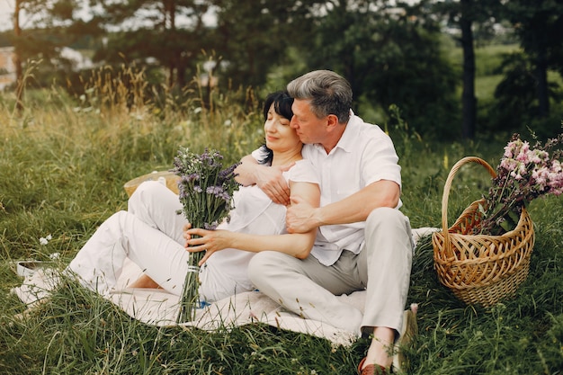 Hermosa pareja adulta pasa tiempo en un campo de verano