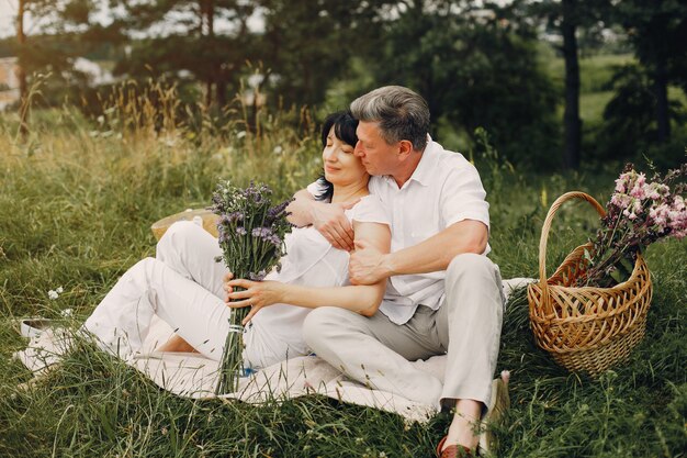 Hermosa pareja adulta pasa tiempo en un campo de verano