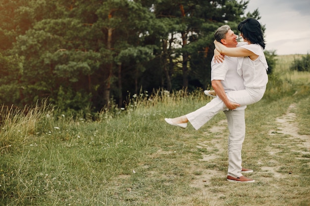 Hermosa pareja adulta pasa tiempo en un campo de verano