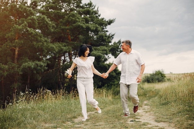 Hermosa pareja adulta pasa tiempo en un campo de verano